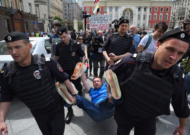 Russian riot police detain activist Nikolai Alexeyev during an unauthorized LGBTI rights rally in Moscow, May 2015. © DMITRY SEREBRYAKOV/AFP/Getty Images