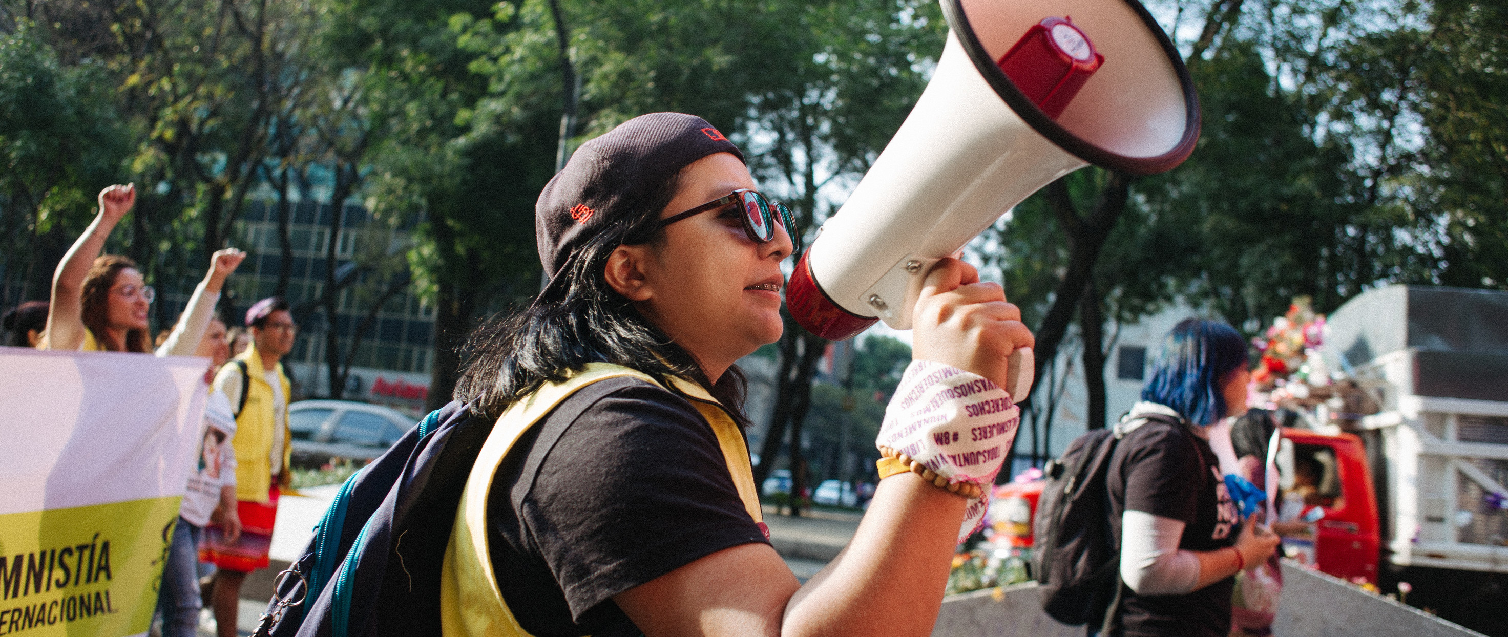 A girl holding a bullhorn in a march with other young people