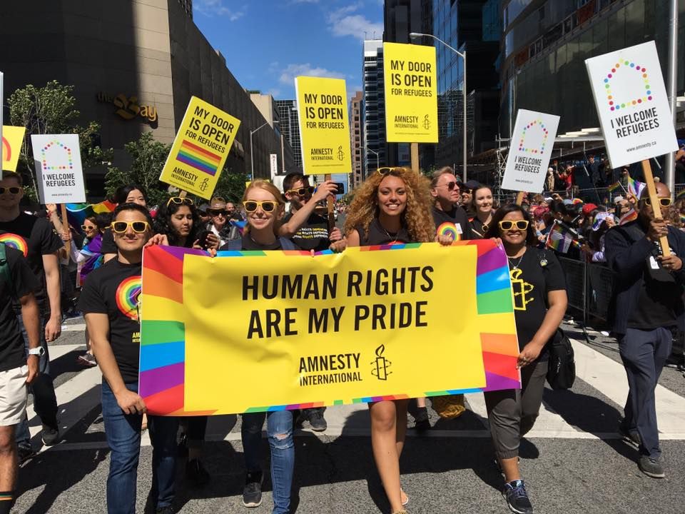 People in Toronto at a pride parade holding a sign that says "Human rights are my pride"