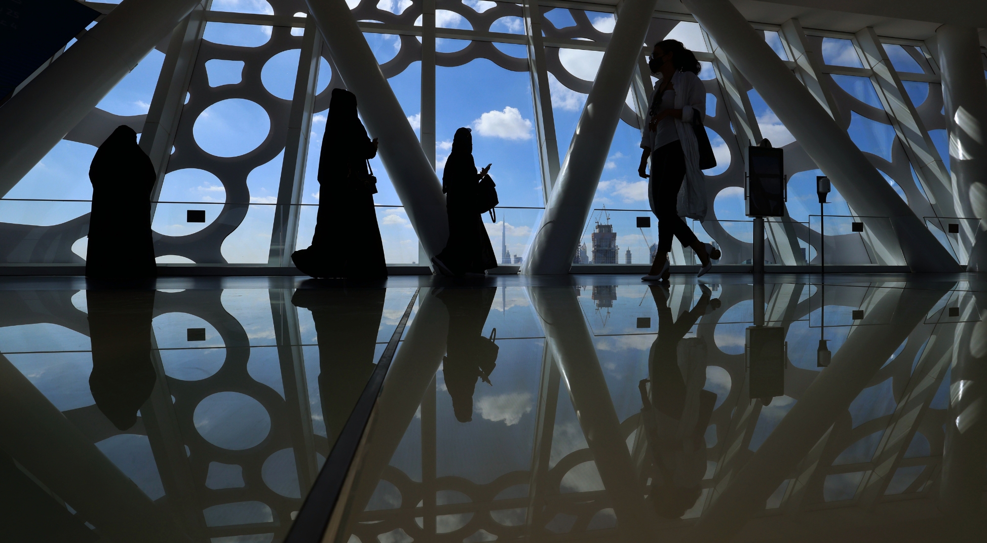 Visitors look on upon a view of downtown Dubai with the Burj Khalifa while standing at the observation deck of the Dubai Frame on February 1, 2021. (Photo by Giuseppe Cacace/AFP via Getty Images)