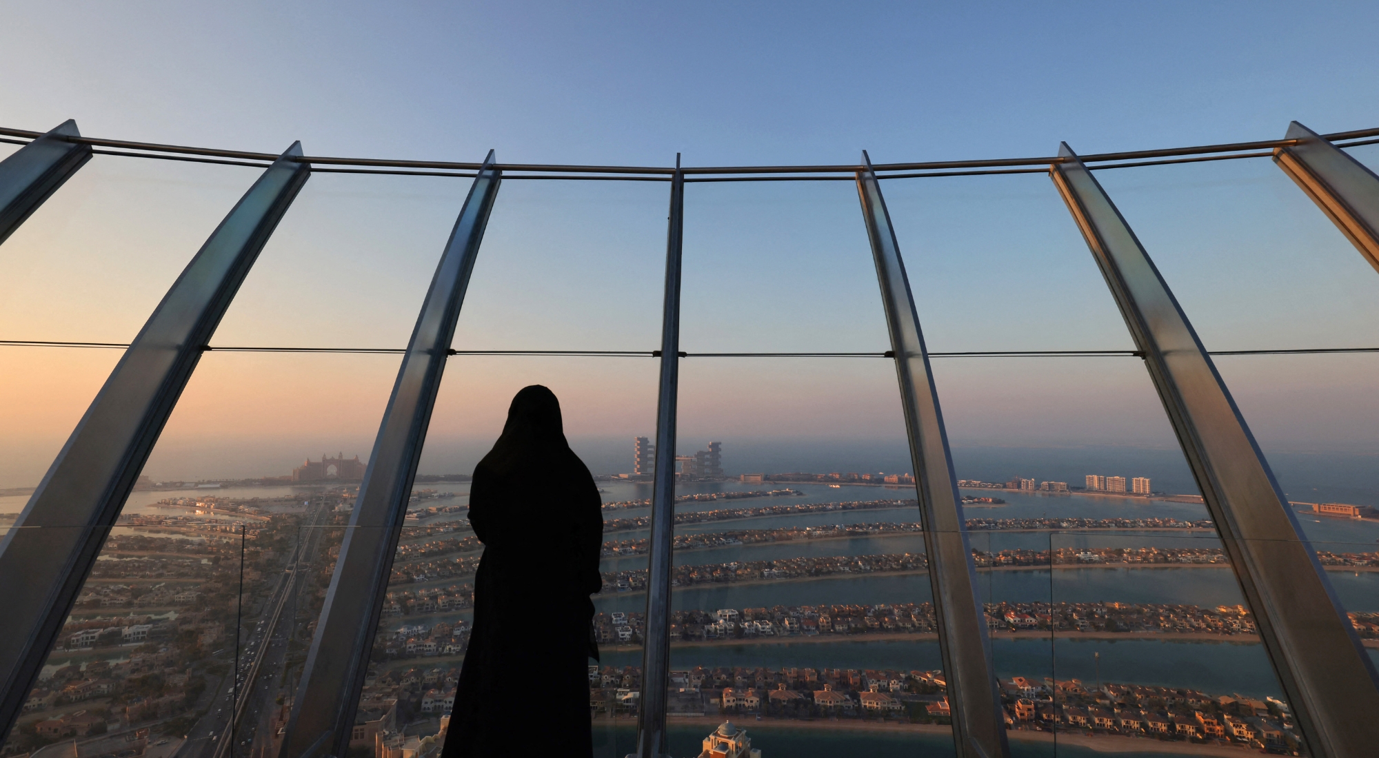 A woman stands at "the View at Palm" overlooking the Palm Jumeirah in the Gulf emirate of Dubai on January 10, 2022. (Photo by Giuseppe CACACE / AFP by Getty Images)