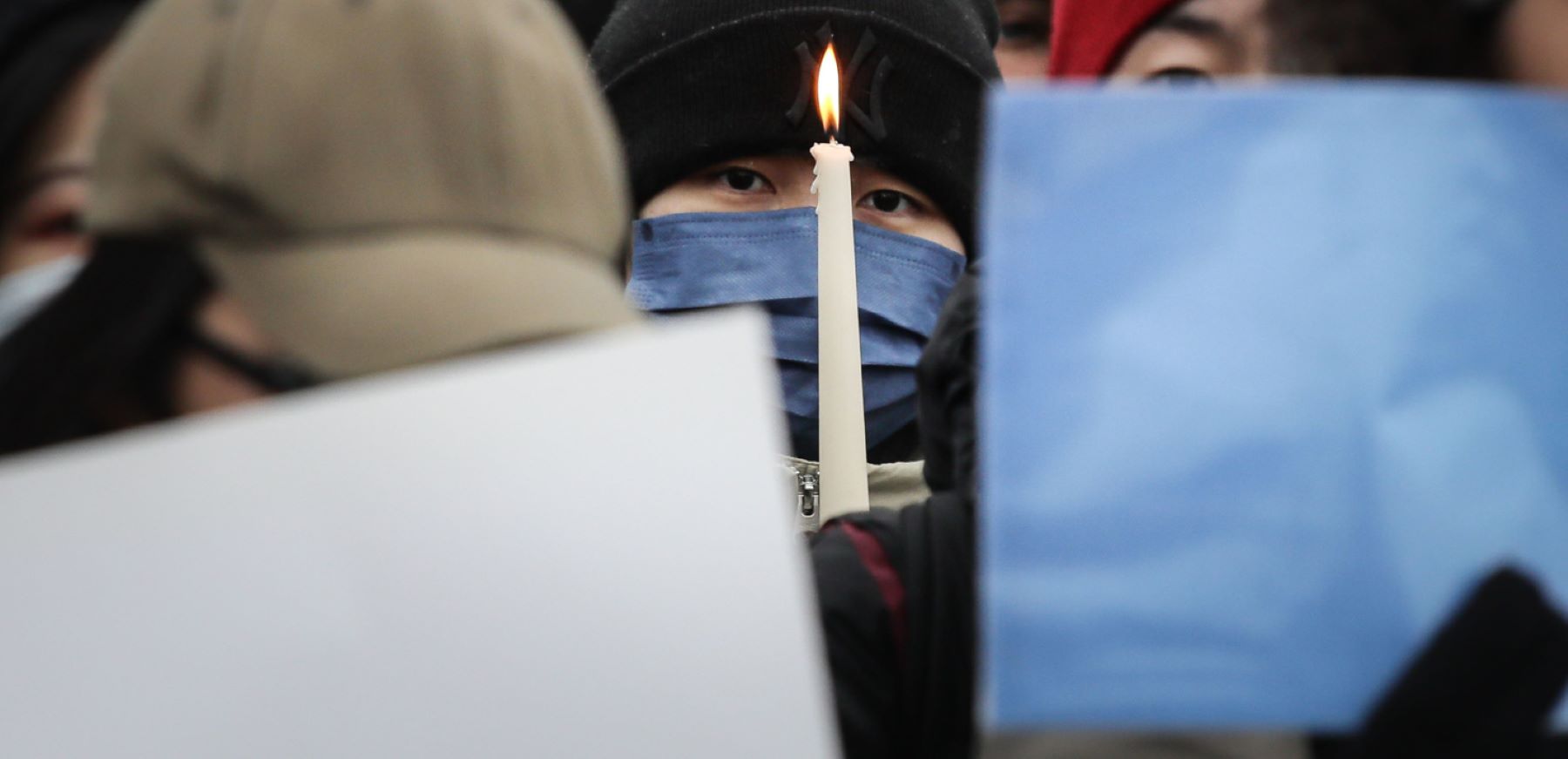 A participant holds a candle as demonstrators protest in front of the Chinese Embassy in solidarity with protesters in China on December 3, 2022 in Berlin, Germany. Protests have been occurring in cities across China recently over the country's ongoing intense Covid lockdowns. A common feature has included protesters holding up blank sheets of A4 paper to symbolize China's heavy-handed enforcement against free speech. (Photo by Omer Messinger/Getty Images)
