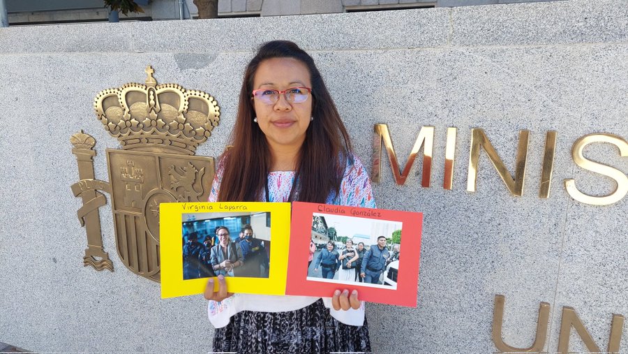 Geraldina Lopez holds up photos of women she represents