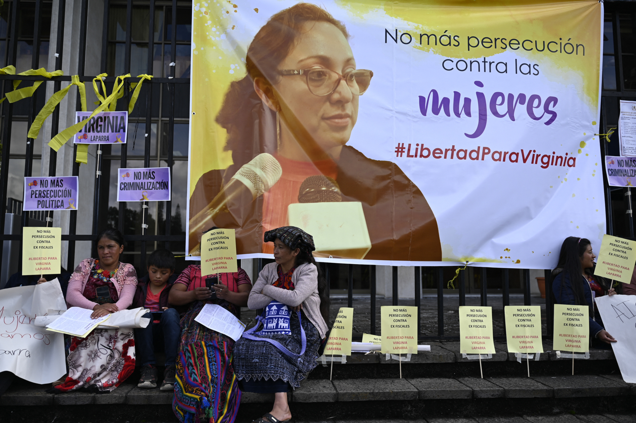 Women protest the jailing of Virginia Laparra with a sign that reads "Stop persecuting women"
