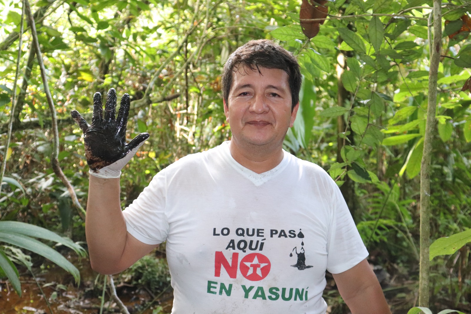 David Moncayo holds up a hand covered in black oil