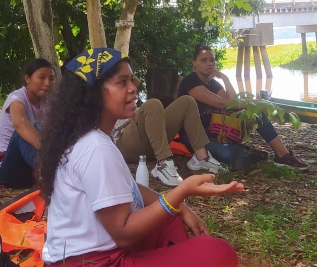 Yuvelis speaks at a gathering of young women beside the river