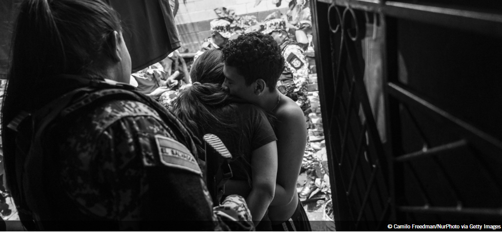 A handcuffed woman is embraced as she is being taken away