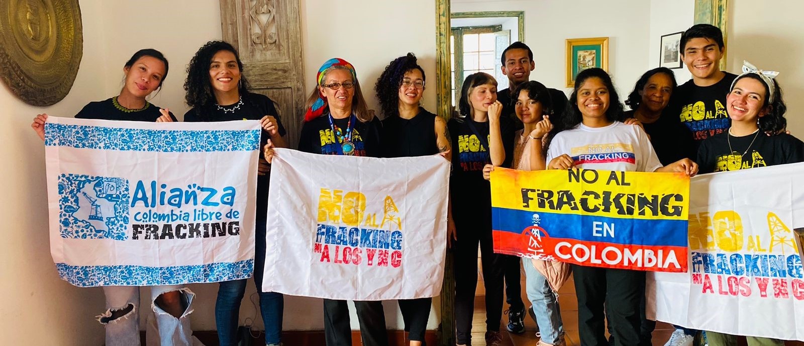 Yuvelis and a group of young people hold banners that say "Alliance Colombia Free of Fracking" and "No to Fracking"