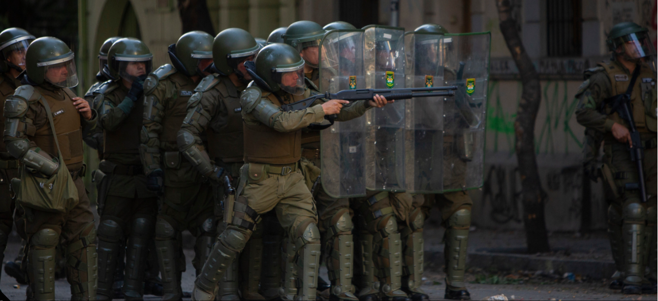 A carabineros aims his rifle