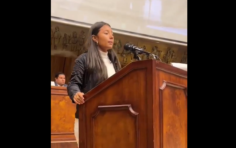 Leonela speaking on a podium