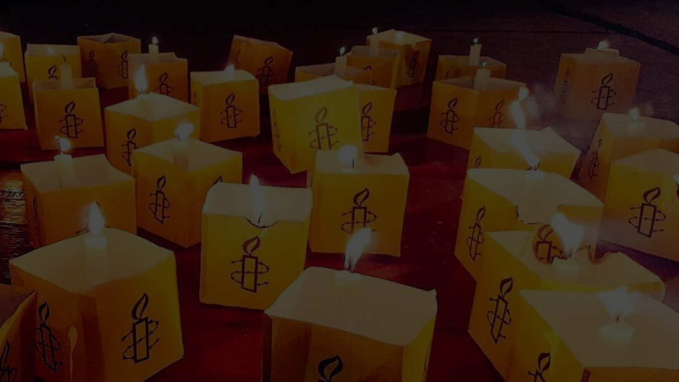 multiple candles with amnesty logo burning together
