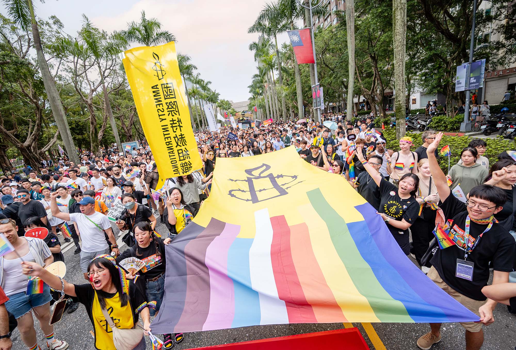 Taiwan Transgender Pride parade with a huge Amnesty pride flag over the crowd