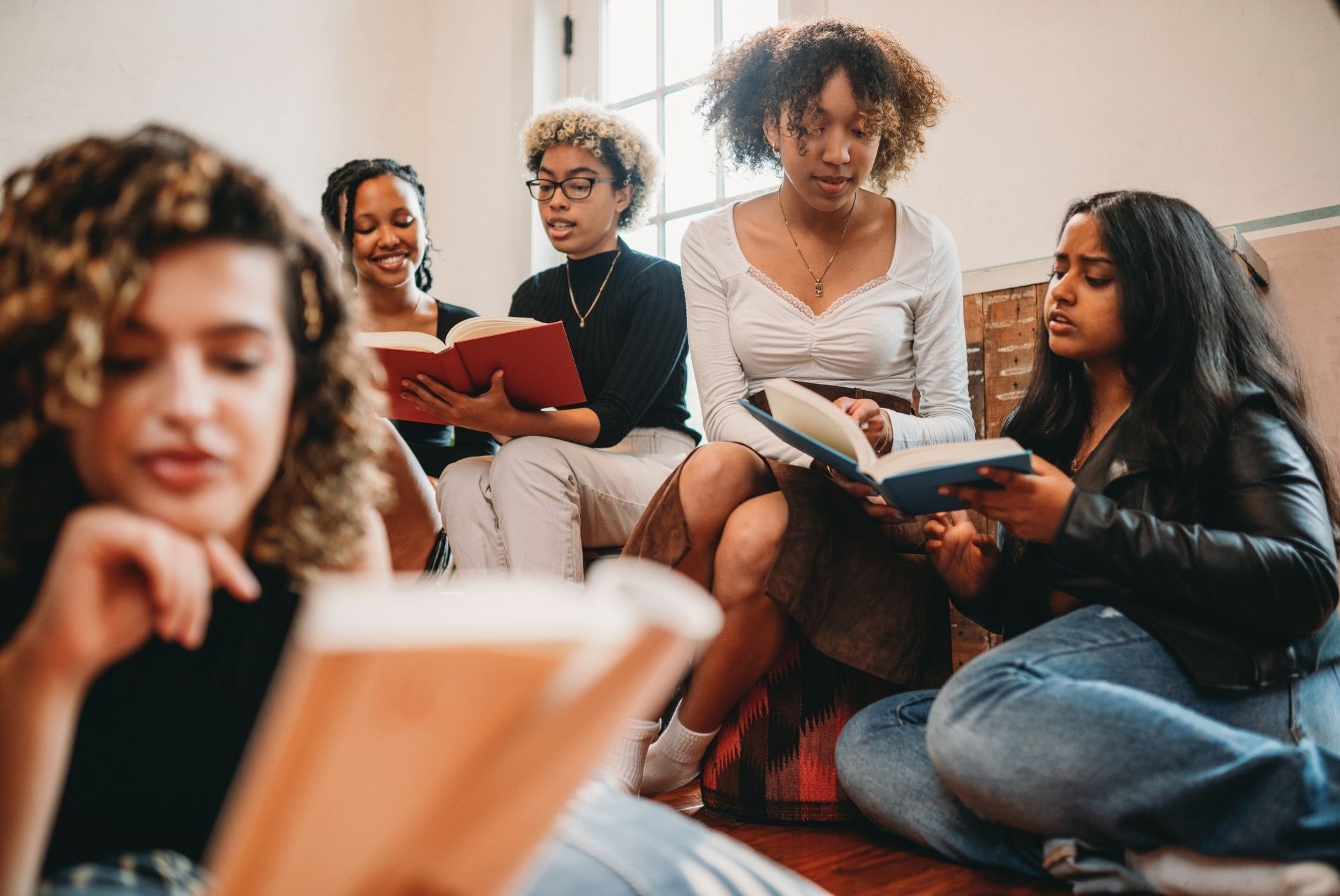 Young women sitting around reading books