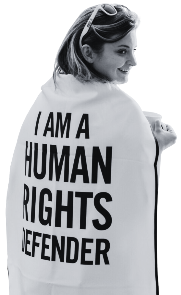 Woman wearing a cape that reads "I am a human rights defender"