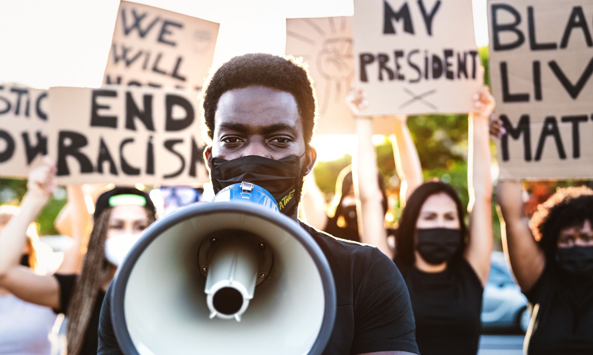 Man with a bull horn and mask on at a black lives matter rally