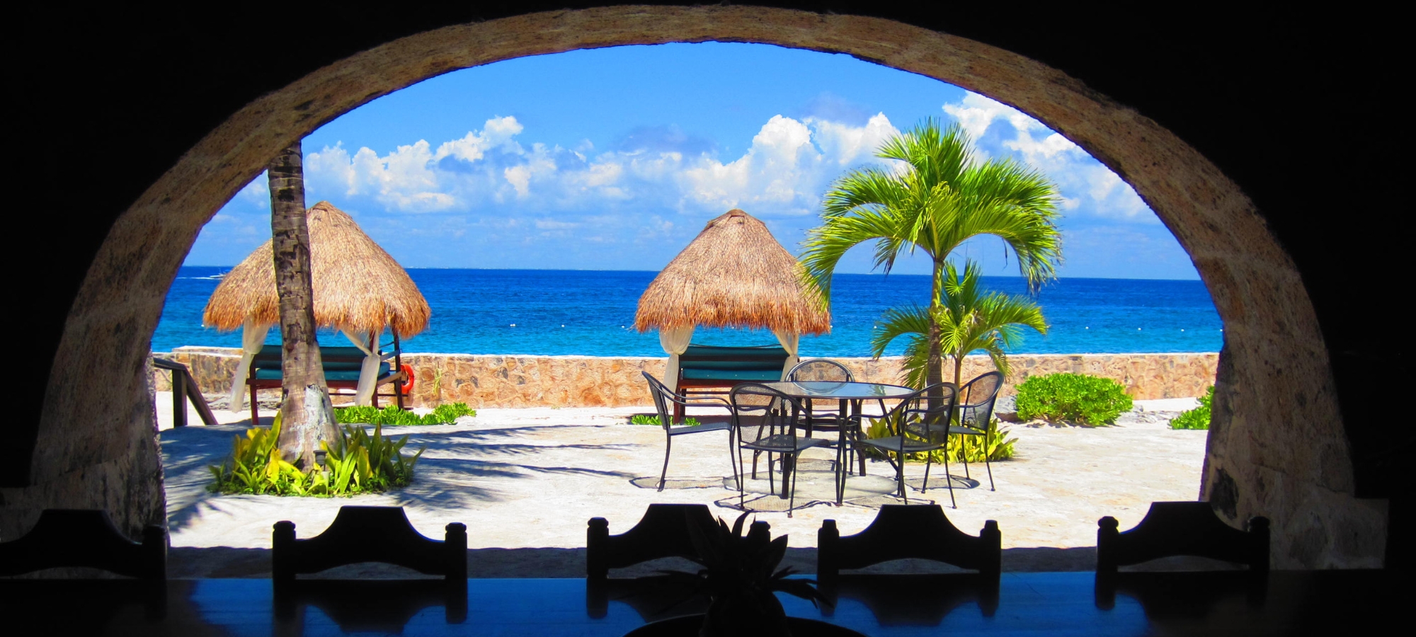 beautiful white sand beach with dark foreground illustrating the dark side of torture in Mexico