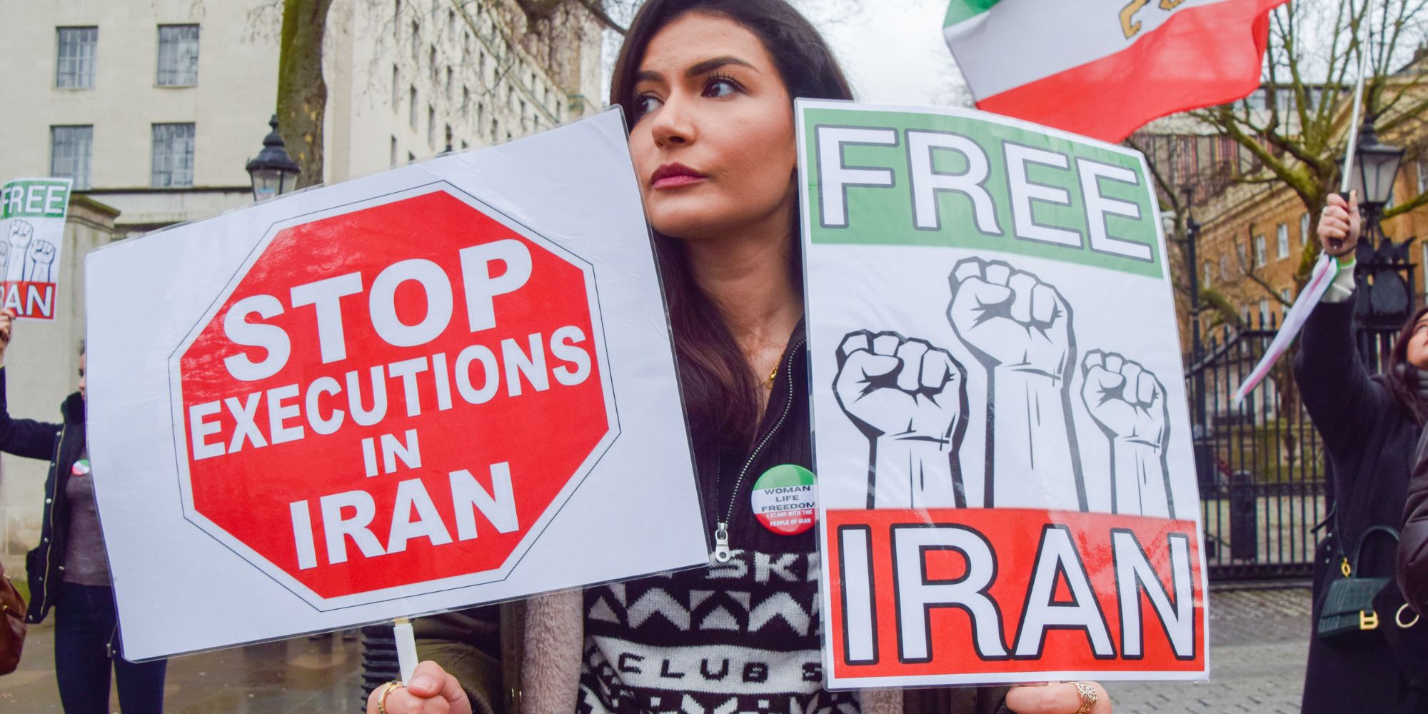 A protester holds 'Stop executions in Iran' and 'Free Iran'