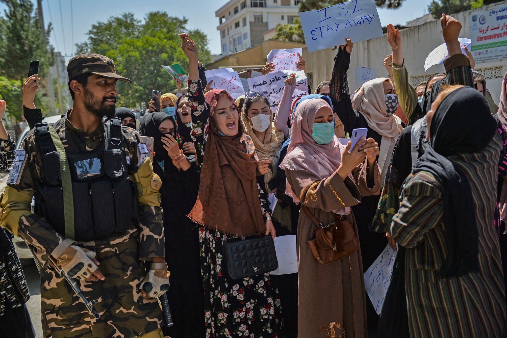 A Taliban fighter stands guard as Afghan women shout slogans during an anti-Pakistan protest rally, near the Pakistan embassy in Kabul on September 7, 2021. - The Taliban on September 7, 2021 fired shots into the air to disperse crowds who had gathered for an anti-Pakistan rally in the capital, the latest protest since the hardline Islamist movement swept to power last month. (Photo by Hoshang Hashimi / AFP) (Photo by HOSHANG HASHIMI/AFP via Getty Images)