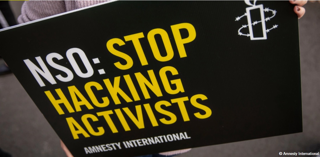 Text on sign says NSO: Stop Hacking Activists