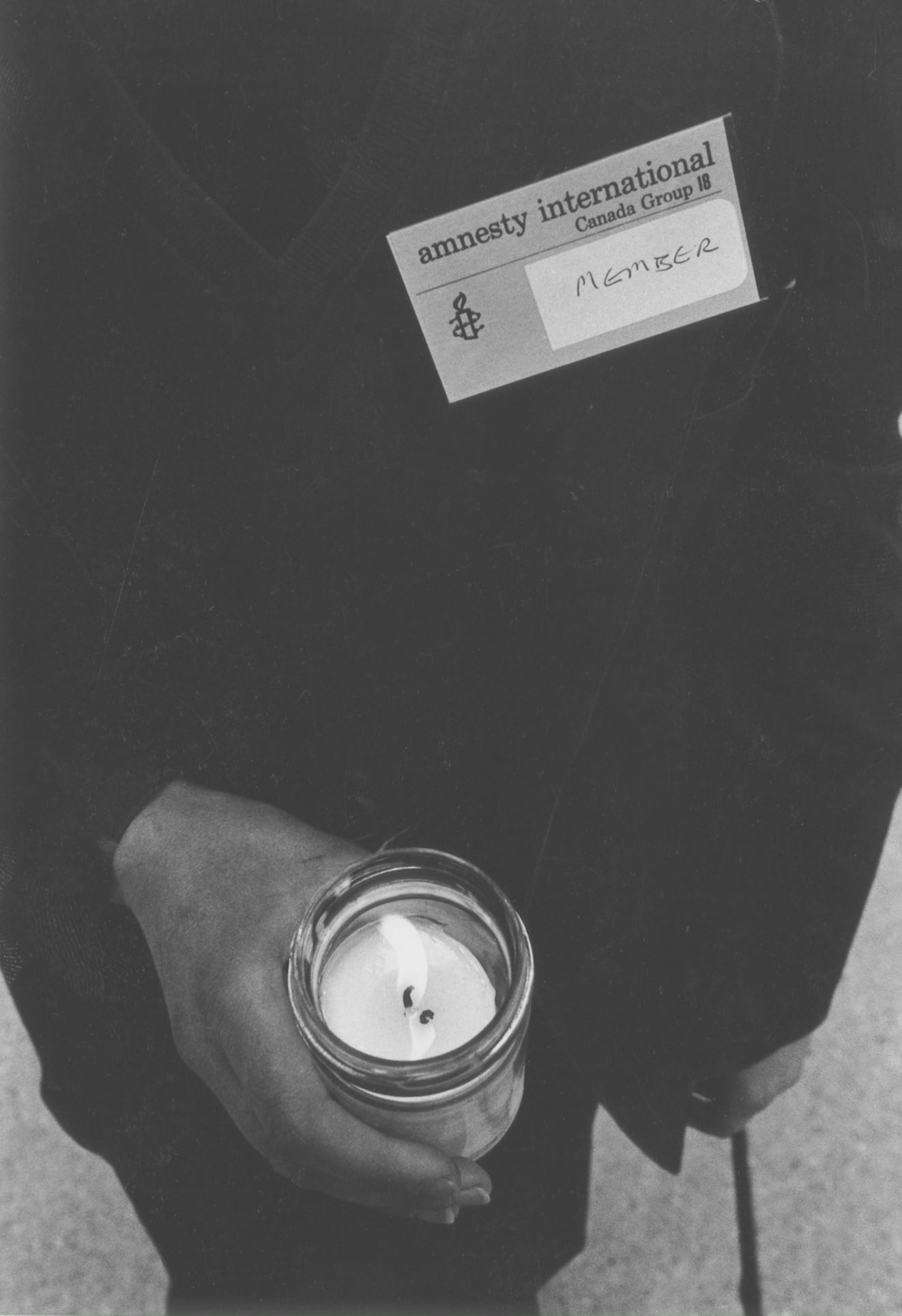 Old photo of AICES member holding candle