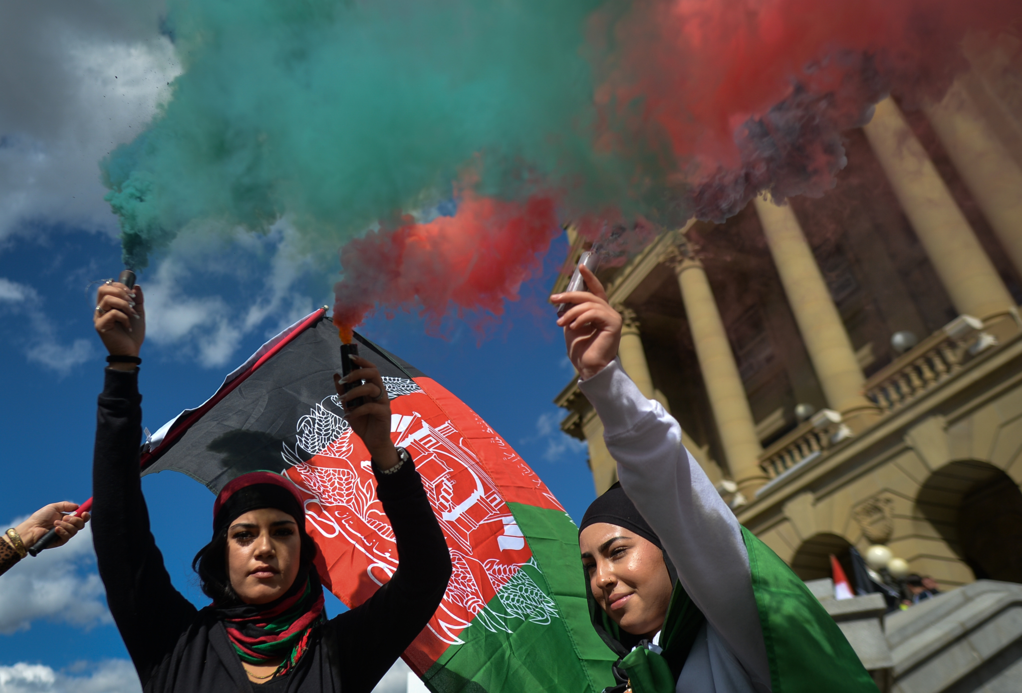Protesters light flares in the colors of Afghanistan. Members of the local Afghan diaspora, activists and local supporters seen in front of the Alberta Legislature Building during the STOP KILLING AFGHANS! protest organised today by the Global Movement of Peace for Afghanistan. Saturday, August 28, 2021, in Edmonton, Alberta, Canada. (Photo by Artur Widak/NurPhoto via Getty Images)