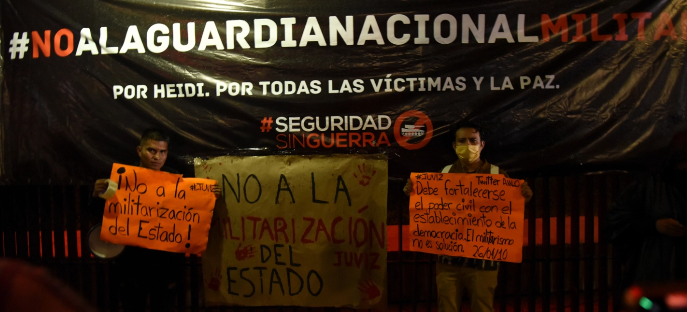 Protestors with sign that say No to Militarization