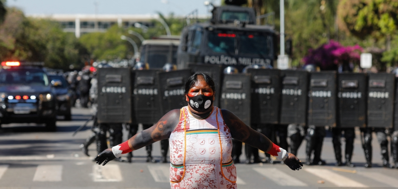 Indigenous woman in protest in front of riot police