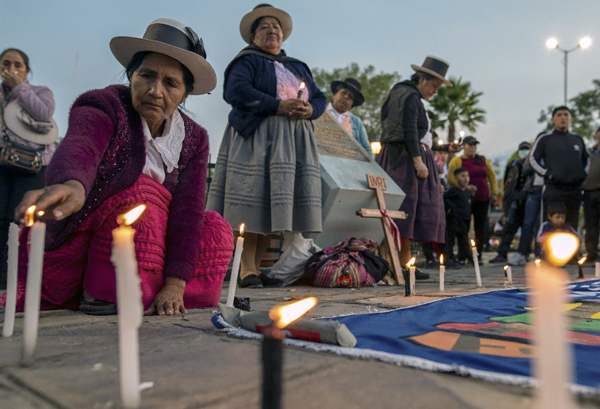 Women in Ayacucho light candles to honour those who have died amid repression of protests since December 7