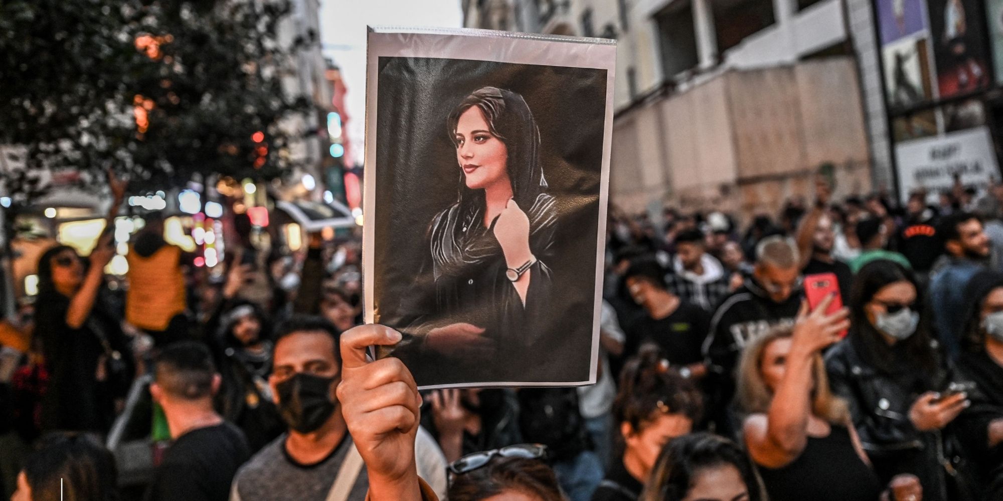 A protester holds a portrait of Mahsa Amini during a demonstration in Turkey in support of Amini, a young Iranian woman who died after being arrested in Tehran by the Islamic Republic's 'morality police.' (Photo by OZAN KOSE/AFP via Getty Images)