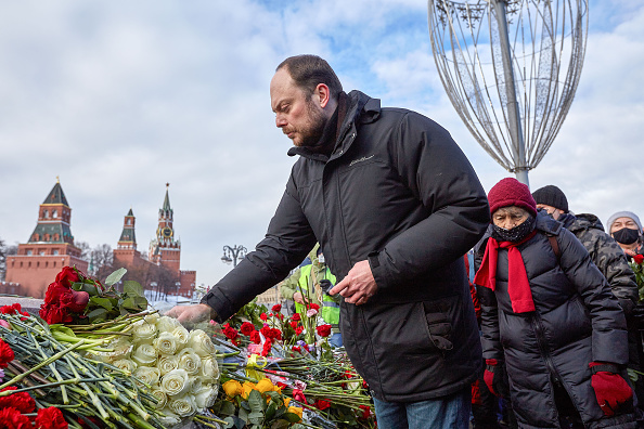 Vladimir Kura-Murza wearing a black winter jacket. He is pictured laying a wreath