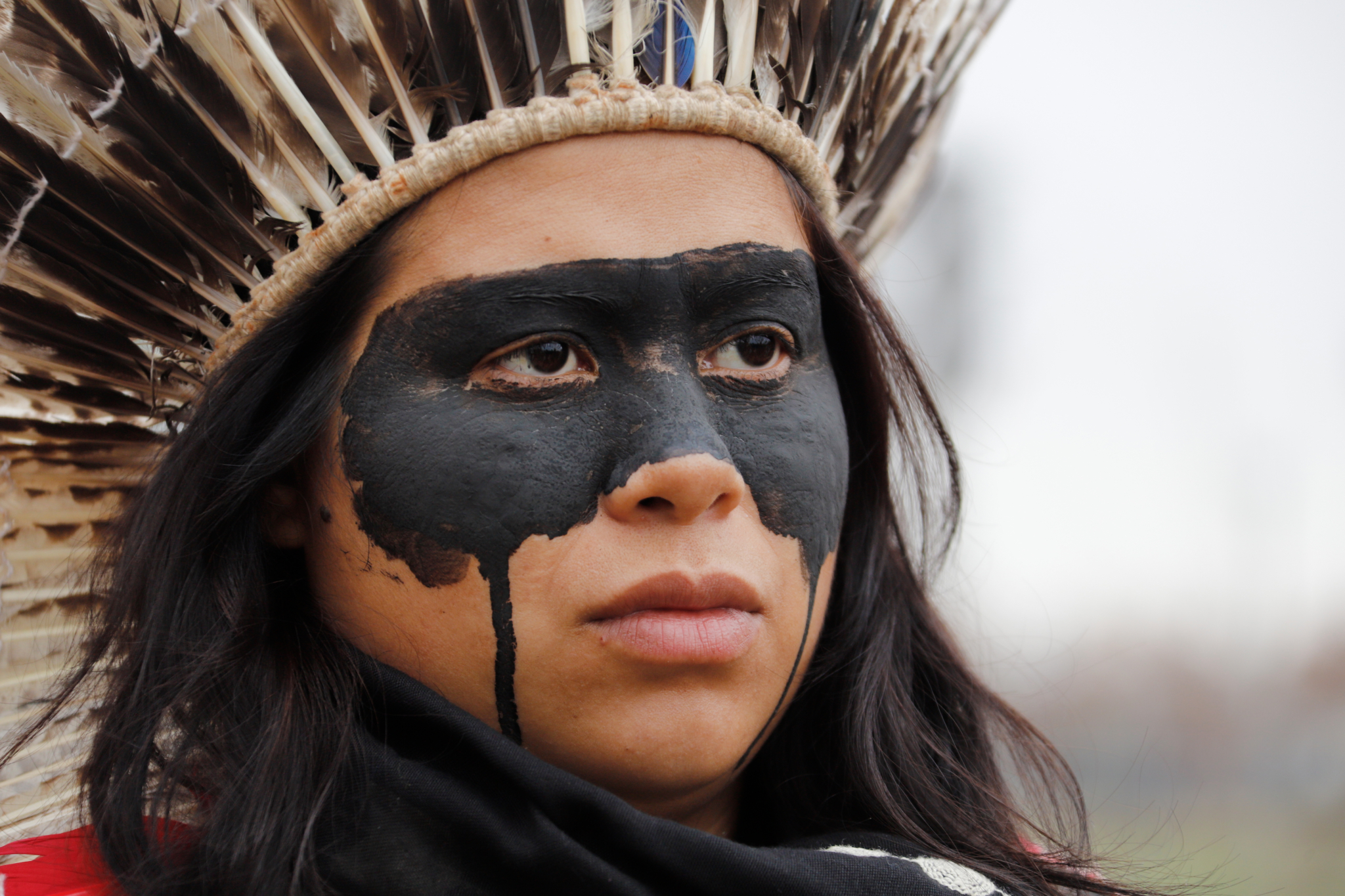 An indigenous protestor with her face painted black to symbolize oil contamination and the fossil fuel industry.
