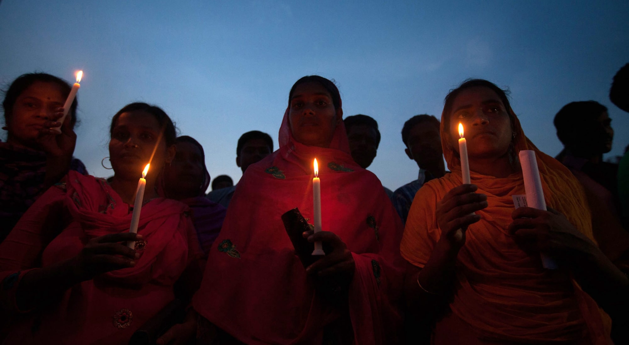 Bangladeshi garment workers and relatives of victims of the Rana Plaza building collapse hold candles during a memorial at the site of the Rana Plaza garment factory building collapse in Savar, on the outskirts of Dhaka on October 24, 2013, the six-month anniversary of the disaster. Relatives of the 1,135 people who lost their lives when the Rana Plaza complex collapsed on April 24 also said they had still to receive any compensation for their loss as they rallied at the site of the tragedy.