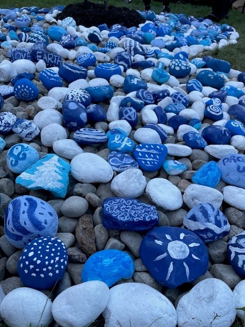  Blue and white painted stones bear symbols of nature and words like "life" and "Love Earth"
