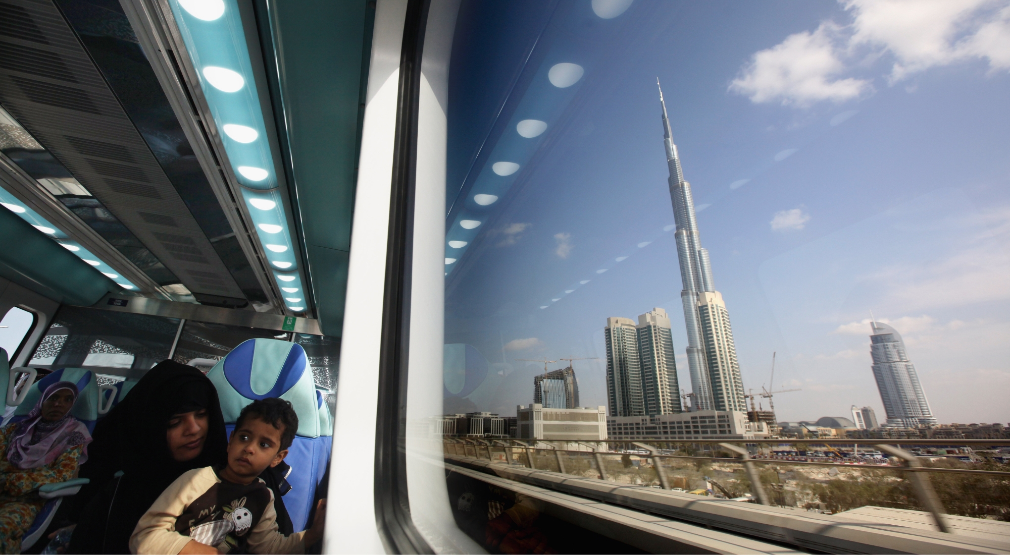 oman and child ride the metro past the Burj Khalifa, the world's tallest building on December 3, 2009 in Dubai, United Arab Emirates. (Photo by Dan Kitwood/Getty Images)