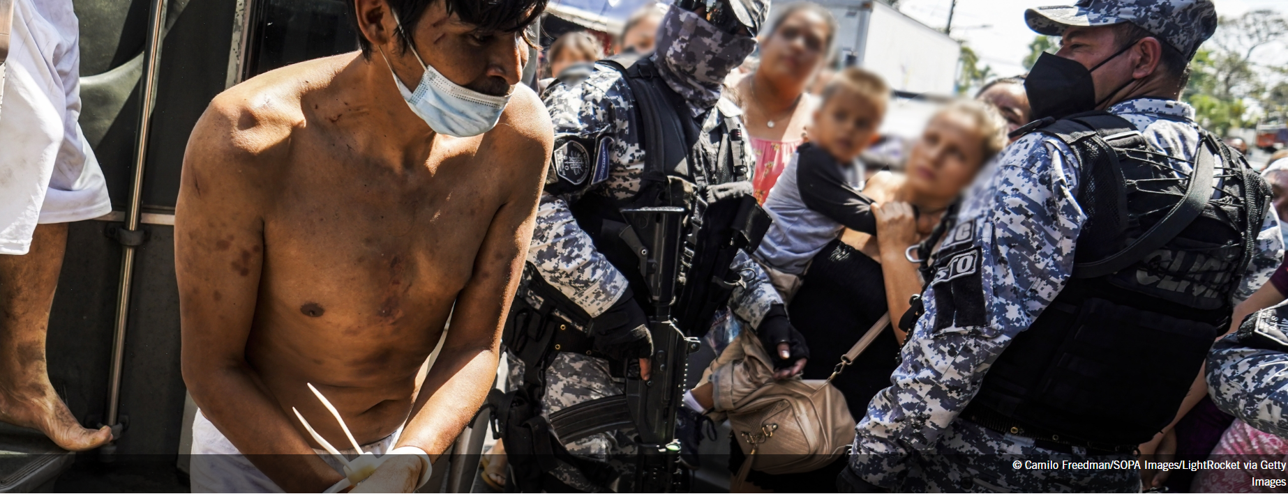 Security forces take detainees off a vehicle