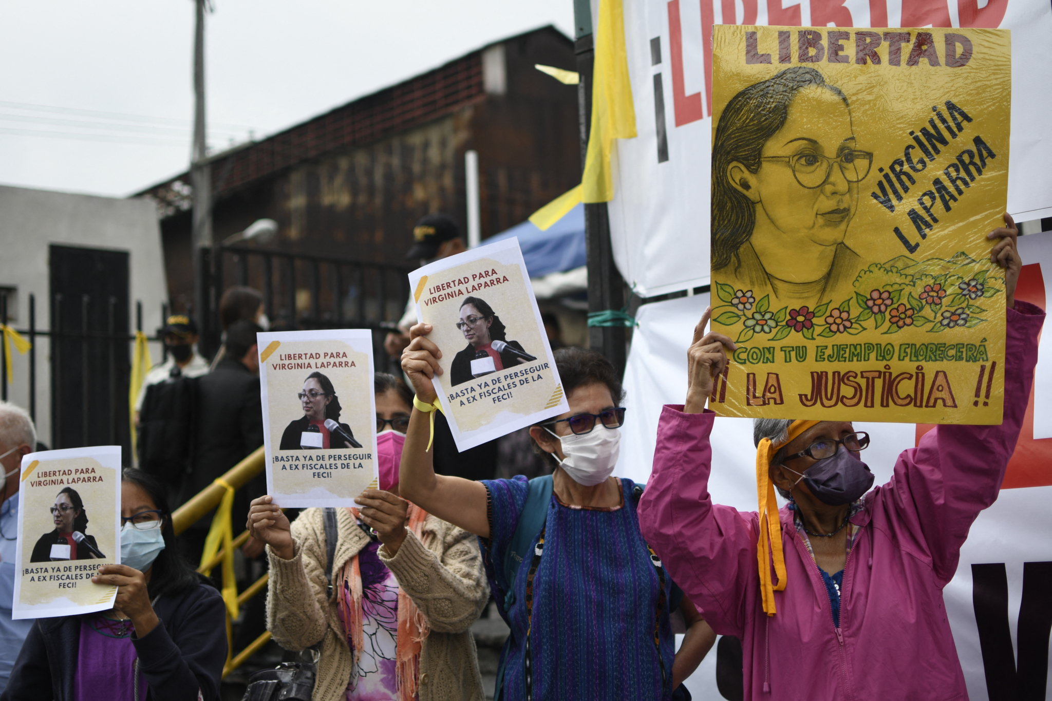 Protestors in Guatemala hold signs denouncing criminalization of prosecutors and human rights defenders
