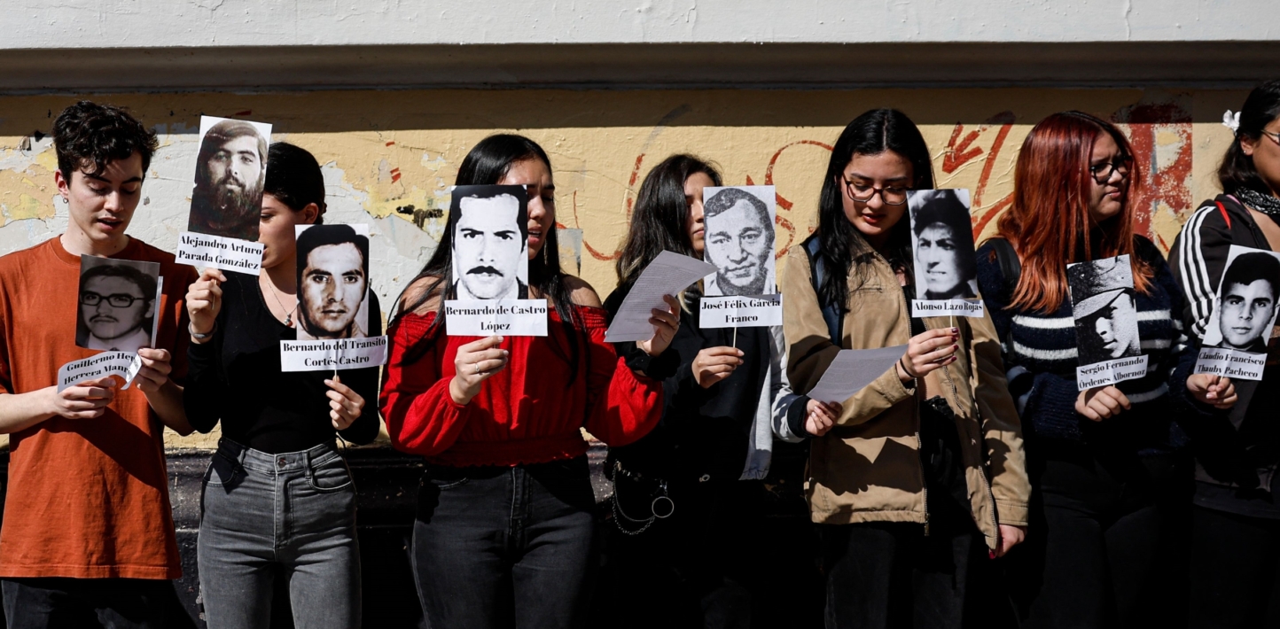 A group of young women hold pictures of victims of the Chilean dictator Augusto Pinochet.