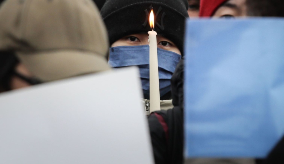 A participant holds a candle as demonstrators protest in front of the Chinese Embassy in solidarity with protesters in China on December 3, 2022 in Berlin, Germany. Protests have been occurring in cities across China recently over the country's ongoing intense Covid lockdowns. A common feature has included protesters holding up blank sheets of A4 paper to symbolize China's heavy-handed enforcement against free speech. (Photo by Omer Messinger/Getty Images)