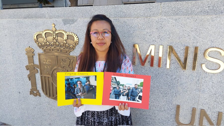 Indigenous lawyer Geraldina Lopez holds photos of Virginia Laparra and Claudia Gonzalez
