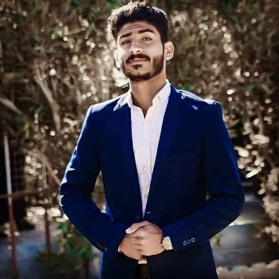Sajjad al Iraqi wearing a dark blue suit over a white shirt