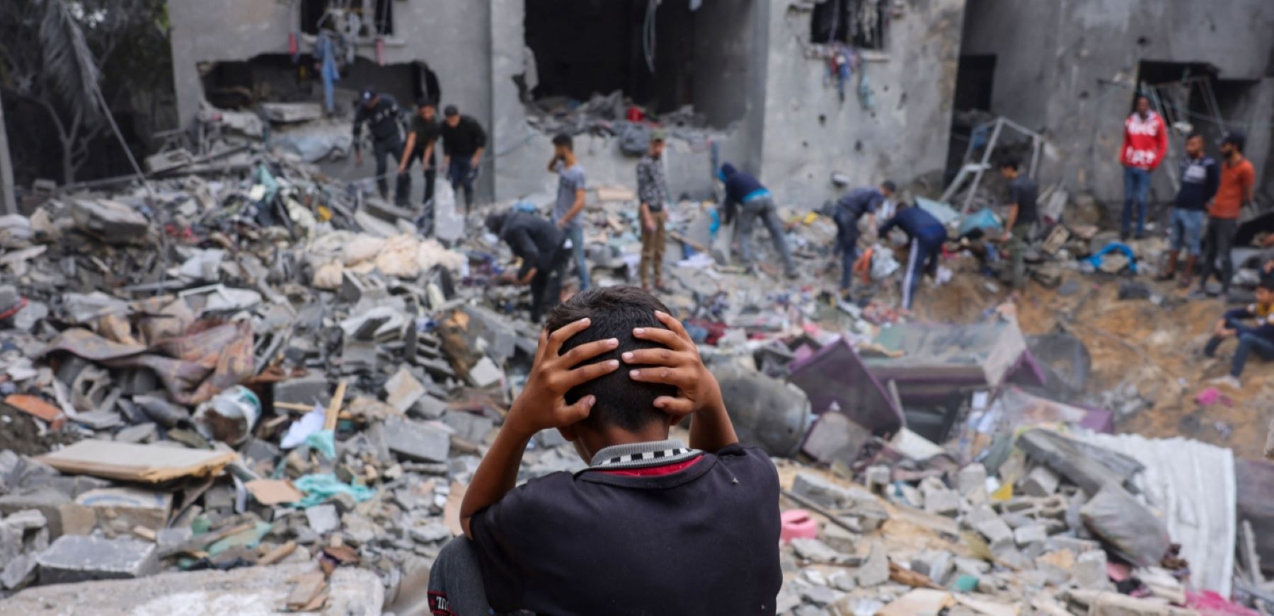A child reacts as people salvage belongings amid the rubble of a damaged building following strikes on Rafah in the southern Gaza Strip, on November 12, 2023, as battles between Israel and the Palestinian Hamas movement continue. Photo by MOHAMMED ABED/AFP via Getty Images.