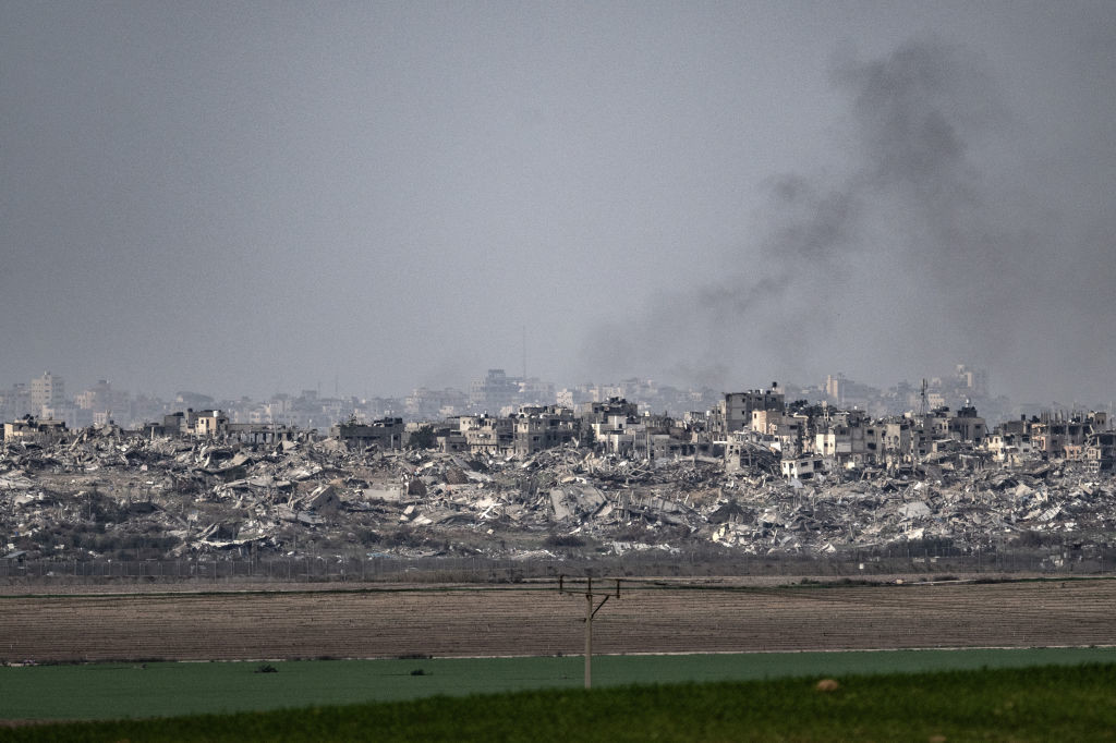 Smoke rises from the rubble of buildings that have been destroyed in military airstrikes