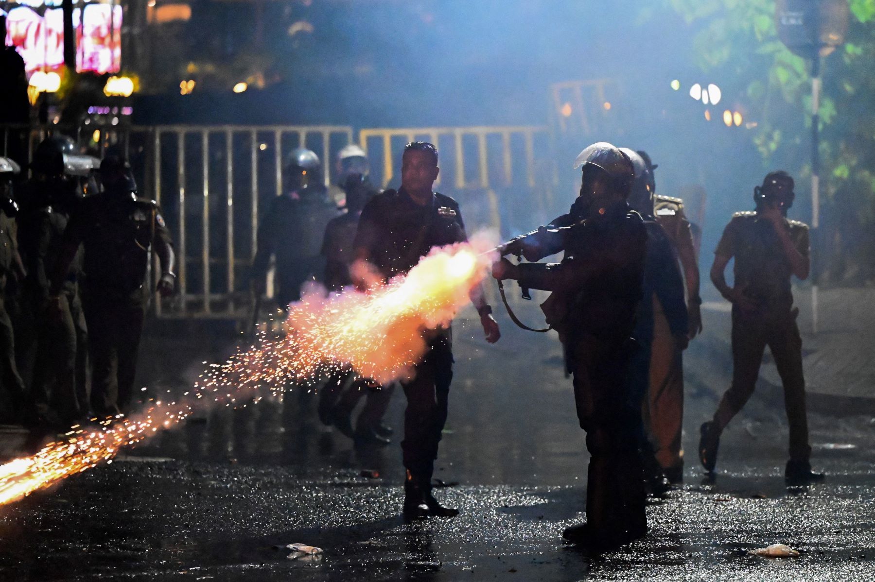 Top image: policeman fires a tear gas canister to disperse protesters during the 50th day of anti-government protests demanding the resignation of Sri Lanka's President Gotabaya Rajapaksa over the country's crippling economic crisis, in Colombo on May 28, 2022. Photo by ISHARA S. KODIKARA/AFP via Getty Images.