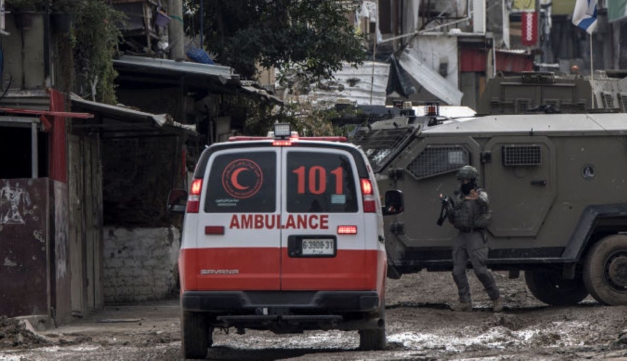 An Israeli soldier gestures towards a Palestinian Red Crescent ambulance at the entrance of the Tulkarem refugee camp in Tulkarem, in the occupied West Bank, on January 17, 2024 during a military operation. Photo by MARCO LONGARI/AFP/Getty Images.