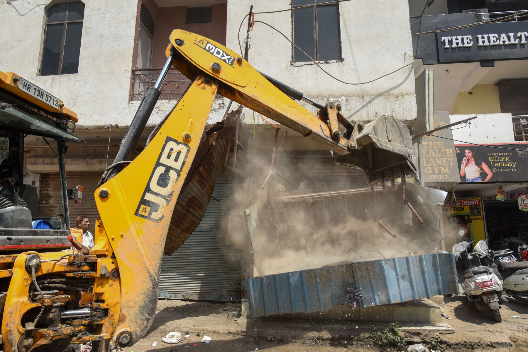 A bulldozer removes encroachments during an anti-encroachment drive by SDMC, at Shyam Nagar (West Delhi), on May 13, 2022 in New Delhi, India. The demolition drive began in Delhi on May 04 and it will continue till May 13. The civic bodies are taking stern action against the illegal land occupation in parts of Delhi. Photo by Sanchit Khanna/Hindustan Times via Getty Images