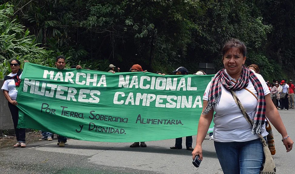 A march with a banner that says National March of Campesina Women for Land, Food Sovereignty and Dignity