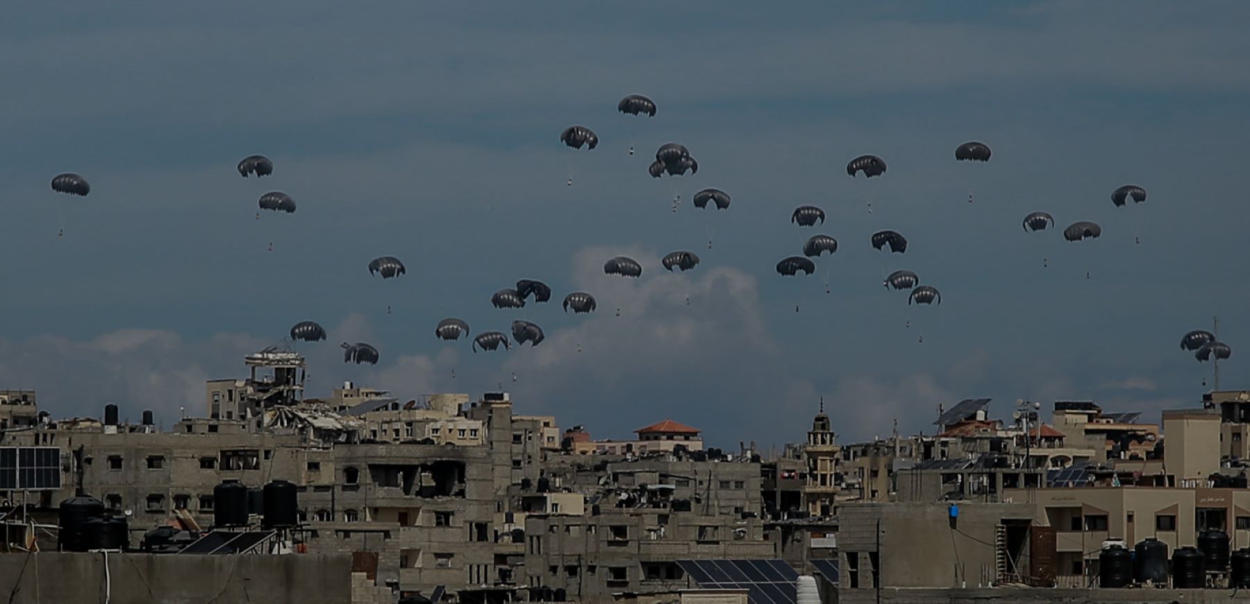 Parachutes filled with aid boxes float down as planes drop humanitarian aid around various regions in the northern Gaza, Gaza on March 09, 2024. Photo by Omar Qattaa/Anadolu via Getty Images.