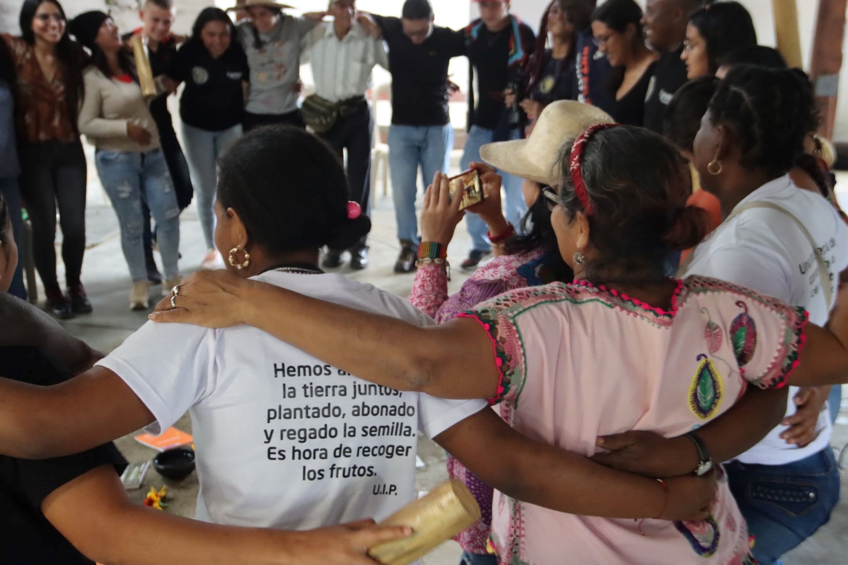 Women confronting risks stand in a circle, their arms round one another