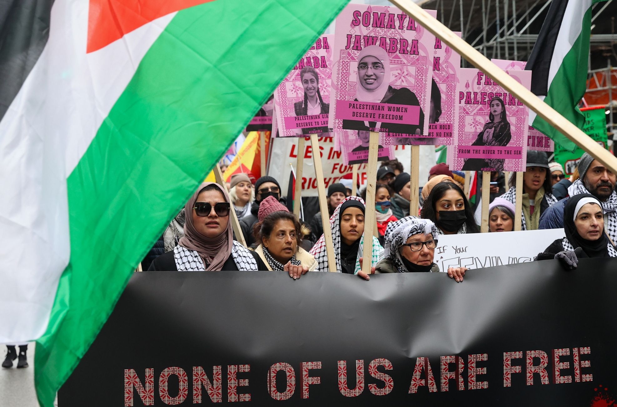 People holding Palestinian flags and portraits of Palestinian women attend Toronto's annual International Women's Day (IWD) march on March 2, 2024 in Ontario, Canada. (Photo by Mert Alper Dervis/Anadolu via Getty Images)