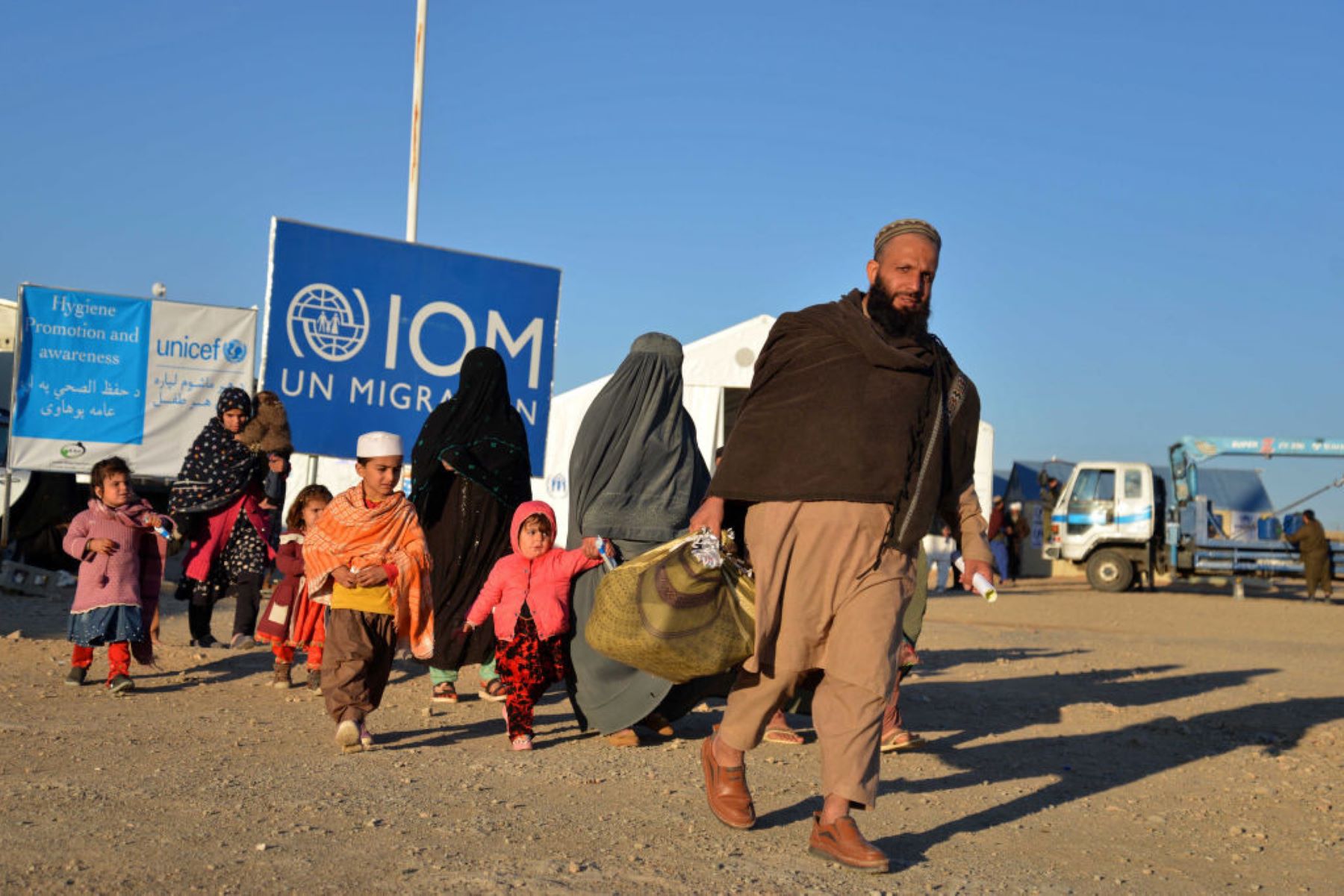 Afghan refugees walk at a registration centre, upon their arrival from Pakistan in Takhta Pul district of Kandahar province on December 18, 2023. Photo by SANAULLAH SEIAM/AFP via Getty Images.